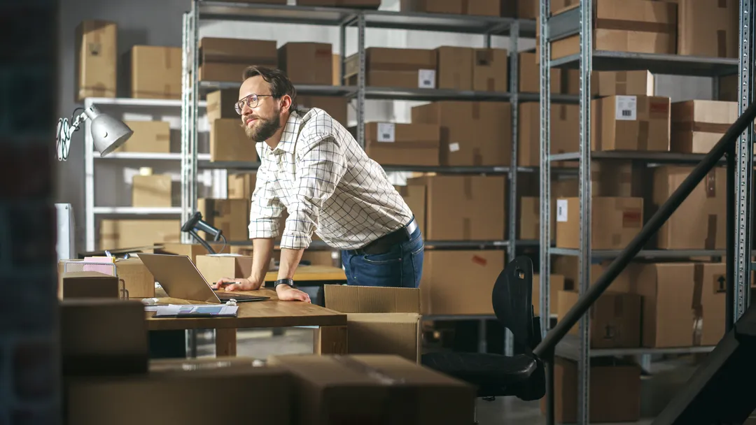 A man looking out over a warehouse, contemplative and forward-looking