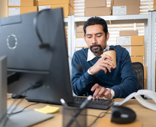 A business owner using HookedGrowth at his desk in the warehouse office